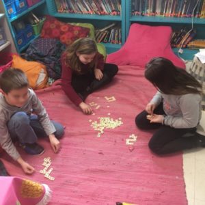 Students sit on floor and play with bananagrams